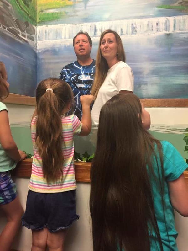 Children gathered at the front of the sanctuary with Pastor Joel and Beth Benson.